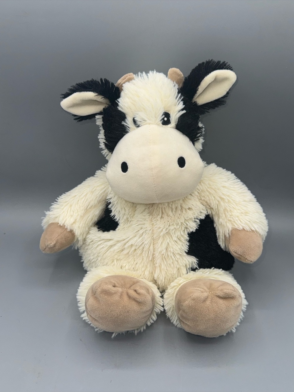 Black and White Cow Warmies, a popular heatable and weighted plush toy